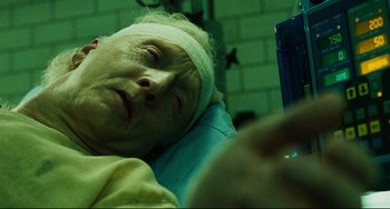 Movie still from “Saw III” (2006), directed by Darren Lynn Bousman – An old man with a bandage on his head is laying in a hospital bed; Close Up shot, High angle
