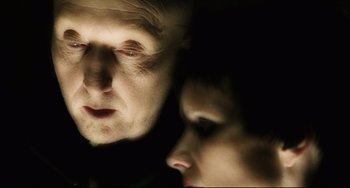 Movie still from “Saw III” (2006), directed by Darren Lynn Bousman – A man and a woman looking at each other in the dark; Close Up shot, Over the shoulder angle