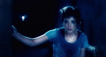 Movie still from “Saw III” (2006), directed by Darren Lynn Bousman – A woman in a blue shirt is holding something in her hand; Medium shot, High angle