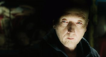 Movie still from “Saw III” (2006), directed by Darren Lynn Bousman – A person wearing a black shirt; Close Up shot, High angle