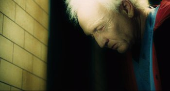 Movie still from “Saw III” (2006), directed by Darren Lynn Bousman – An older man with white hair looking down at the ground; Close Up shot, Low angle