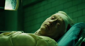 Movie still from “Saw III” (2006), directed by Darren Lynn Bousman – An old man laying on a hospital bed with bandages on his head; Close Up shot, High angle