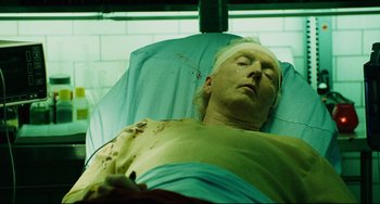Movie still from “Saw III” (2006), directed by Darren Lynn Bousman – A man with a bandaged head is lying in a hospital bed; Close Up shot, High angle