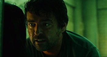 Movie still from “Saw III” (2006), directed by Darren Lynn Bousman – A person wearing a green shirt; Close Up shot, Low angle