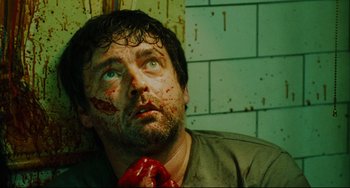 Movie still from “Saw III” (2006), directed by Darren Lynn Bousman – A person wearing a tie with blood all over his face; Close Up shot, Overhead angle