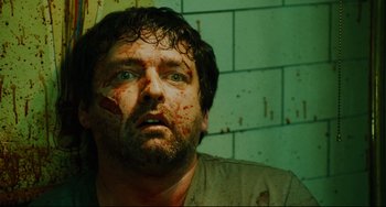 Movie still from “Saw III” (2006), directed by Darren Lynn Bousman – A person with blood all over his face; Close Up shot, Overhead angle