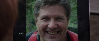 Movie still from “Official Competition” (2021), directed by Gastón Duprat – A person smiling for the camera; Close Up shot, High angle