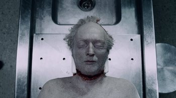 Movie still from “Saw IV” (2007), directed by Darren Lynn Bousman – An old man with a neck brace and a head wound; Close Up shot, Overhead angle