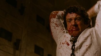 Movie still from “Saw IV” (2007), directed by Darren Lynn Bousman – A man with blood all over his face and neck; Close Up shot, Low angle