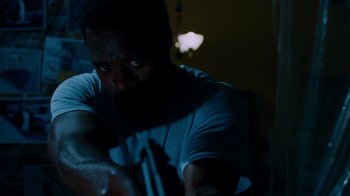 Movie still from “Saw IV” (2007), directed by Darren Lynn Bousman – A man holding a gun in a dark room; Close Up shot, Low angle