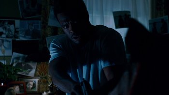 Movie still from “Saw IV” (2007), directed by Darren Lynn Bousman – A man holding a video game controller in a dark room; Close Up shot, Over the shoulder angle