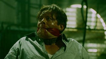 Movie still from “Saw IV” (2007), directed by Darren Lynn Bousman – A man with a bandage on his face and neck; Close Up shot, Low angle