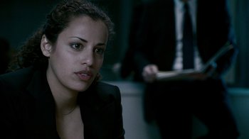 Movie still from “Saw IV” (2007), directed by Darren Lynn Bousman – A woman sitting in a dark room looking at the camera; Close Up shot, Over the shoulder angle