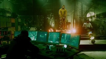 Movie still from “Saw IV” (2007), directed by Darren Lynn Bousman – A man standing in front of multiple computer monitors; Wide shot, Over the shoulder angle