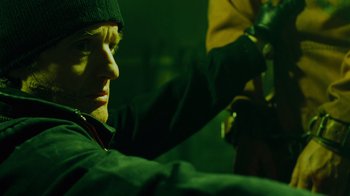 Movie still from “Saw IV” (2007), directed by Darren Lynn Bousman – A man wearing a black hat and a green jacket; Close Up shot, Low angle