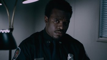 Movie still from “Saw IV” (2007), directed by Darren Lynn Bousman – A man in a police uniform looking at the camera; Close Up shot, Low angle