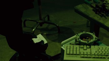 Movie still from “Saw IV” (2007), directed by Darren Lynn Bousman – A computer keyboard sitting on top of a desk; Extreme Close Up shot, High angle