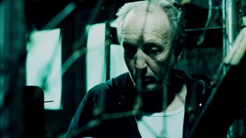 Movie still from “Saw IV” (2007), directed by Darren Lynn Bousman – An older man looking out of a window at night; Close Up shot, Low angle