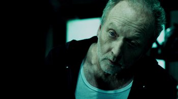 Movie still from “Saw IV” (2007), directed by Darren Lynn Bousman – An older man is looking at the camera; Close Up shot, Low angle