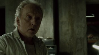 Movie still from “Saw IV” (2007), directed by Darren Lynn Bousman – An older man is looking into the camera; Close Up shot, Over the shoulder angle