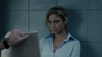 Movie still from “Saw IV” (2007), directed by Darren Lynn Bousman – A woman sitting in front of a wall holding a book; Close Up shot, Over the shoulder angle