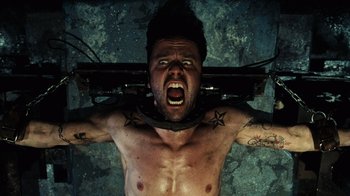 Movie still from “Saw V” (2008), directed by David Hackl – A man with a tattoo on his neck and chest is laying in the water; Close Up shot, Overhead angle