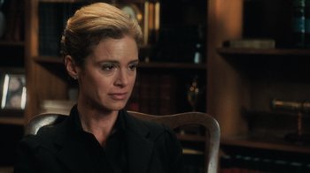 Movie still from “Saw V” (2008), directed by David Hackl – A woman sitting in a chair in front of a bookshelf; Close Up shot, Over the shoulder angle