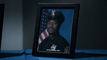 Movie still from “Saw V” (2008), directed by David Hackl – A picture of a police officer in a uniform; Close Up shot, High angle