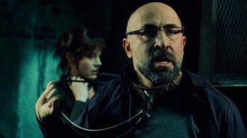 Movie still from “Saw V” (2008), directed by David Hackl – A man and a woman are in a dark room; Close Up shot, Over the shoulder angle