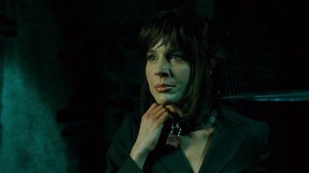 Movie still from “Saw V” (2008), directed by David Hackl – A woman in a black suit and a black tie; Close Up shot, Over the shoulder angle