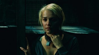 Movie still from “Saw V” (2008), directed by David Hackl – A woman with blonde hair wearing a black shirt; Close Up shot, High angle