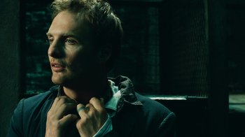 Movie still from “Saw V” (2008), directed by David Hackl – A man in a jacket is fixing his tie; Close Up shot, High angle