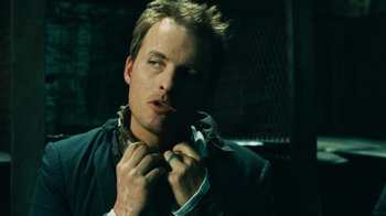 Movie still from “Saw V” (2008), directed by David Hackl – A person putting on a jacket; Close Up shot, Low angle