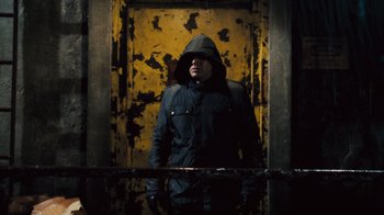 A man standing in front of a door wearing a jacket