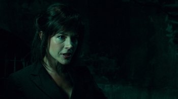 Movie still from “Saw V” (2008), directed by David Hackl – A woman in a black jacket is in the dark; Close Up shot, Over the shoulder angle