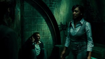 Movie still from “Saw V” (2008), directed by David Hackl – A man and a woman are standing in a dark room; Medium shot, Low angle