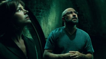 Movie still from “Saw V” (2008), directed by David Hackl – A man with a beard and glasses looking at himself in the mirror; Medium shot, Low angle