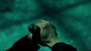 Movie still from “Saw V” (2008), directed by David Hackl – A hand holding a cell phone in a dark room; Extreme Close Up shot, Overhead angle