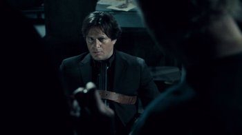 Movie still from “Saw V” (2008), directed by David Hackl – A man in a black jacket and a brown leather belt; Close Up shot, Over the shoulder angle