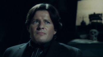 Movie still from “Saw V” (2008), directed by David Hackl – A person wearing a suit and tie; Close Up shot, Low angle