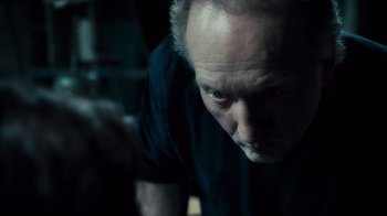 Movie still from “Saw V” (2008), directed by David Hackl – An older man is looking down at the floor; Close Up shot, Over the shoulder angle