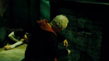 An older man standing in front of a brick fireplace