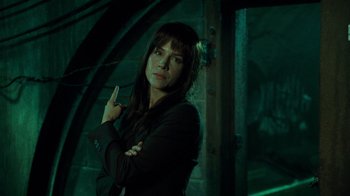 Movie still from “Saw V” (2008), directed by David Hackl – A woman in a black shirt is posing for a picture; Close Up shot, Over the shoulder angle