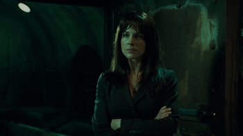 Movie still from “Saw V” (2008), directed by David Hackl – A woman standing in a dark room with her arms crossed; Close Up shot, Low angle