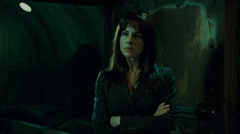 Movie still from “Saw V” (2008), directed by David Hackl – A woman standing in a dark room with her arms crossed; Close Up shot, Low angle