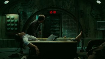 Movie still from “Saw V” (2008), directed by David Hackl – Two men are laying in a bath tub in a dark room; Wide shot, High angle