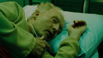 Movie still from “Saw V” (2008), directed by David Hackl – An older man laying in a hospital bed; Close Up shot, High angle