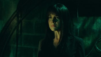 Movie still from “Saw V” (2008), directed by David Hackl – A woman with long black hair standing next to a brick wall; Close Up shot, Low angle