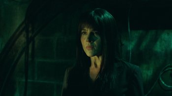 Movie still from “Saw V” (2008), directed by David Hackl – A woman with long hair and a black shirt is in the dark; Close Up shot, Low angle