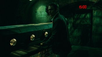 Movie still from “Saw V” (2008), directed by David Hackl – A man standing next to an electric meter; Medium shot, High angle